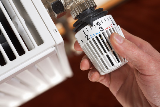 Hand turns heating thermostat to approx. 2.5
