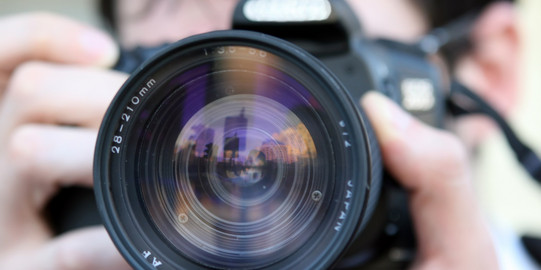 Close up of man looking through camera lens