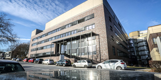 a modern grey-brown building with four floors